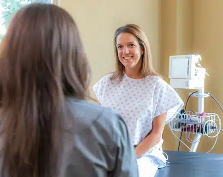 Patient in scrubs in exam room